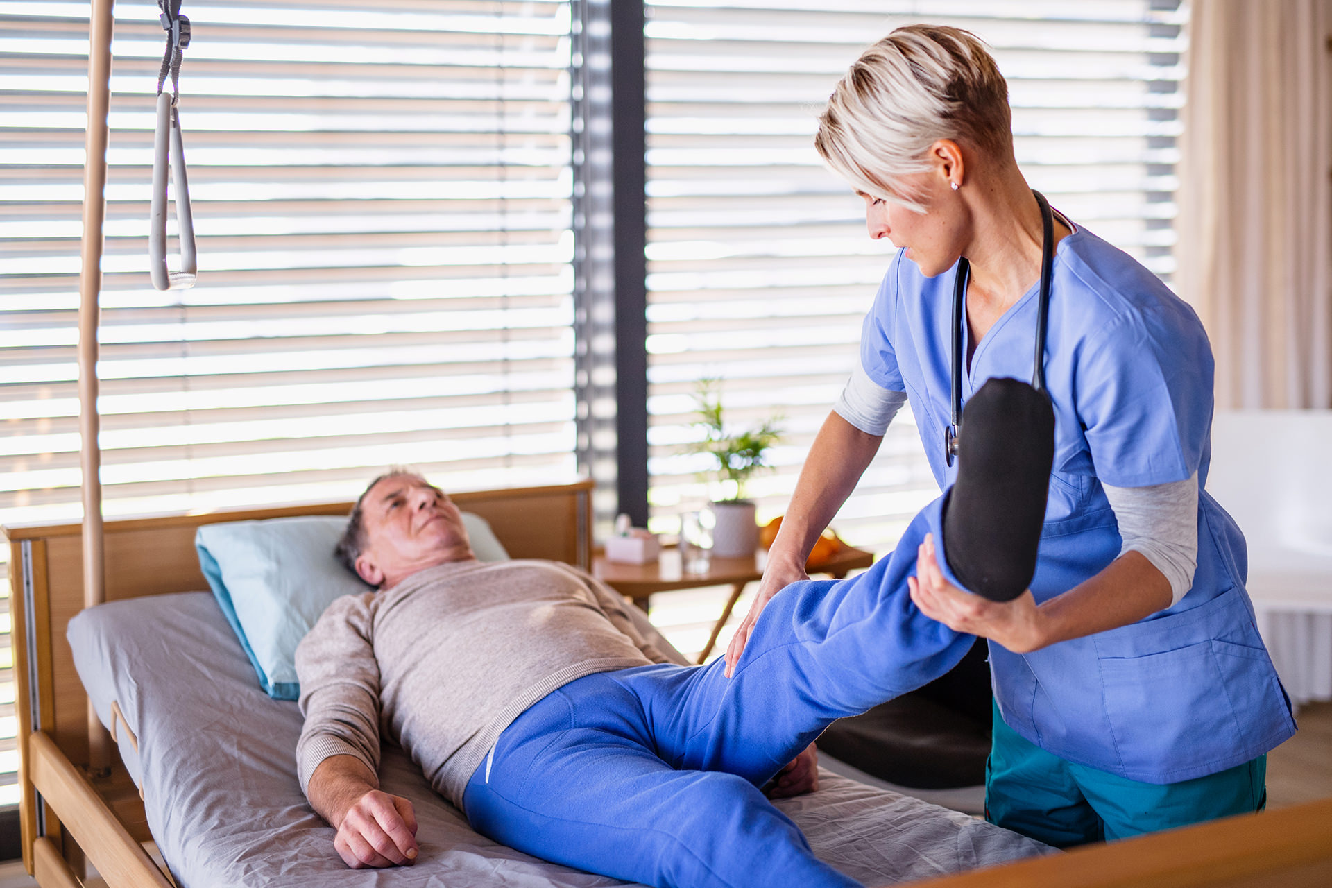 A healthcare worker and senior patient in hospital, physiotherapy.